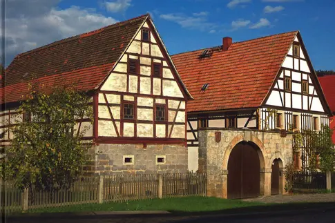 Buch-Cover mit Foto eines Bauernhofes mit zwei großen Fachwerkhäusern, darüber der Titel des Buches