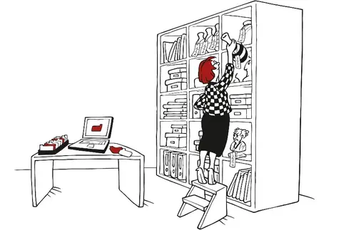 Eine Frau streckt sich, um vom oberen Boden eines großen, mit diversen Objekten gefüllten Regals eine Vase zu greifen. Neben dem Regal steht ein Schreibtisch mit Laptop und Karteikarten. Sie pflegt Objekte in eine Datenbank ein.