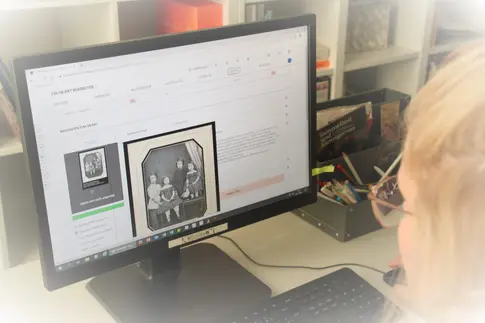 Blick über die Schulter einer Person auf einen aufgeklappten Laptop, auf dem an einer Datenbank gearbeitet wird